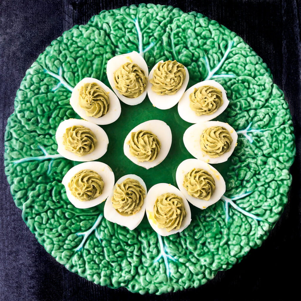 green decorative plate with keto deviled eggs with green goddess spices