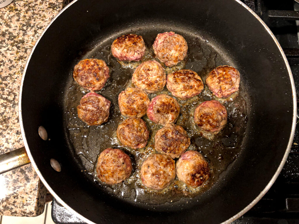 gluten free meatballs frying in a pan