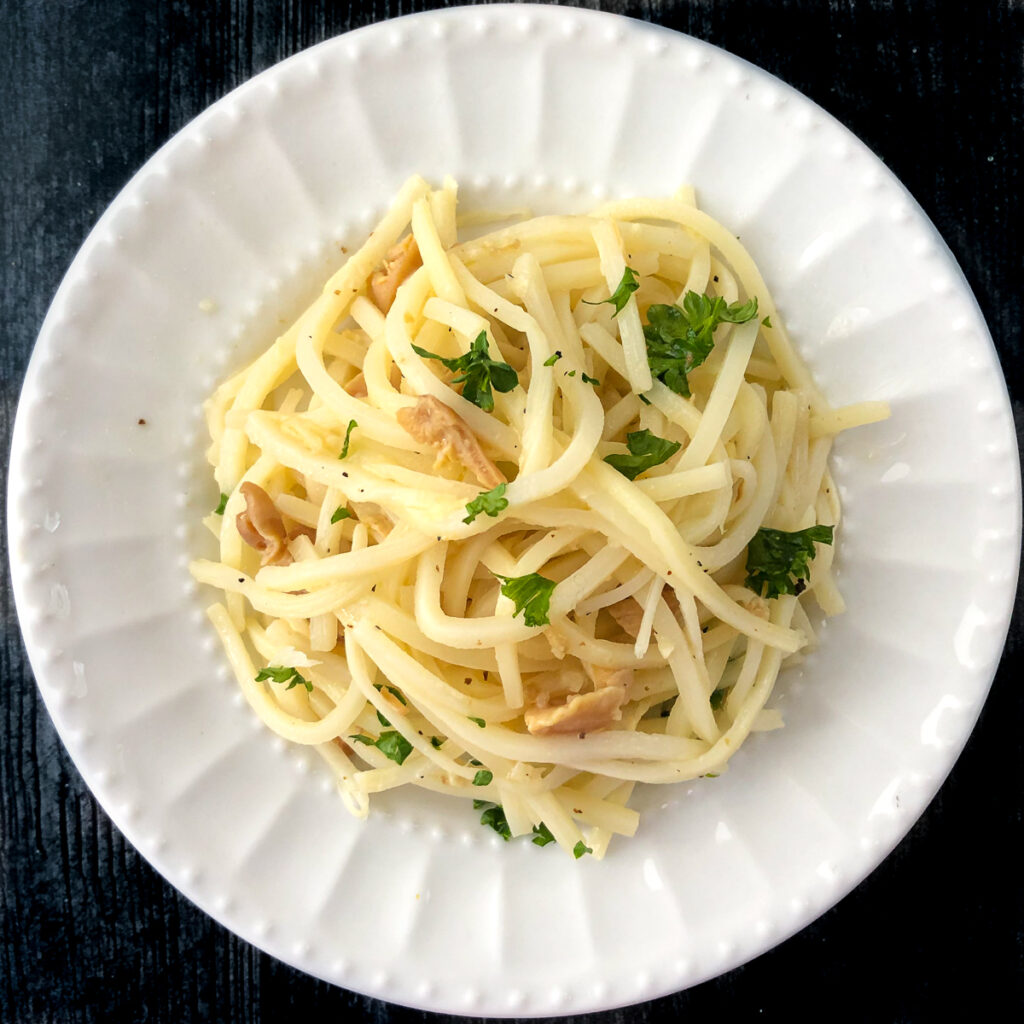 white plate with keto Palmini linguine with clam sauce