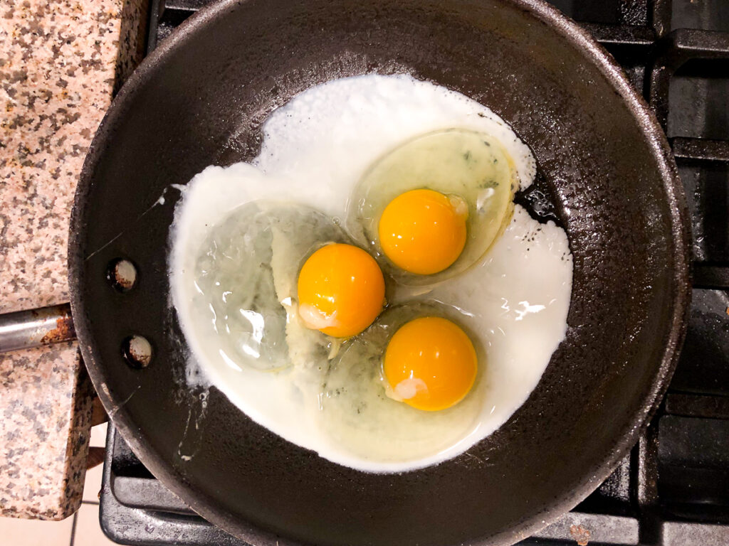 skillet with 3 eggs frying