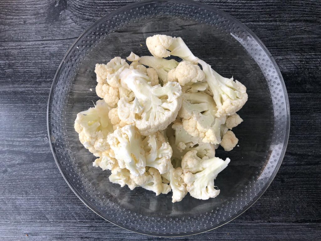 cooked cauliflower florets in a glass bowl