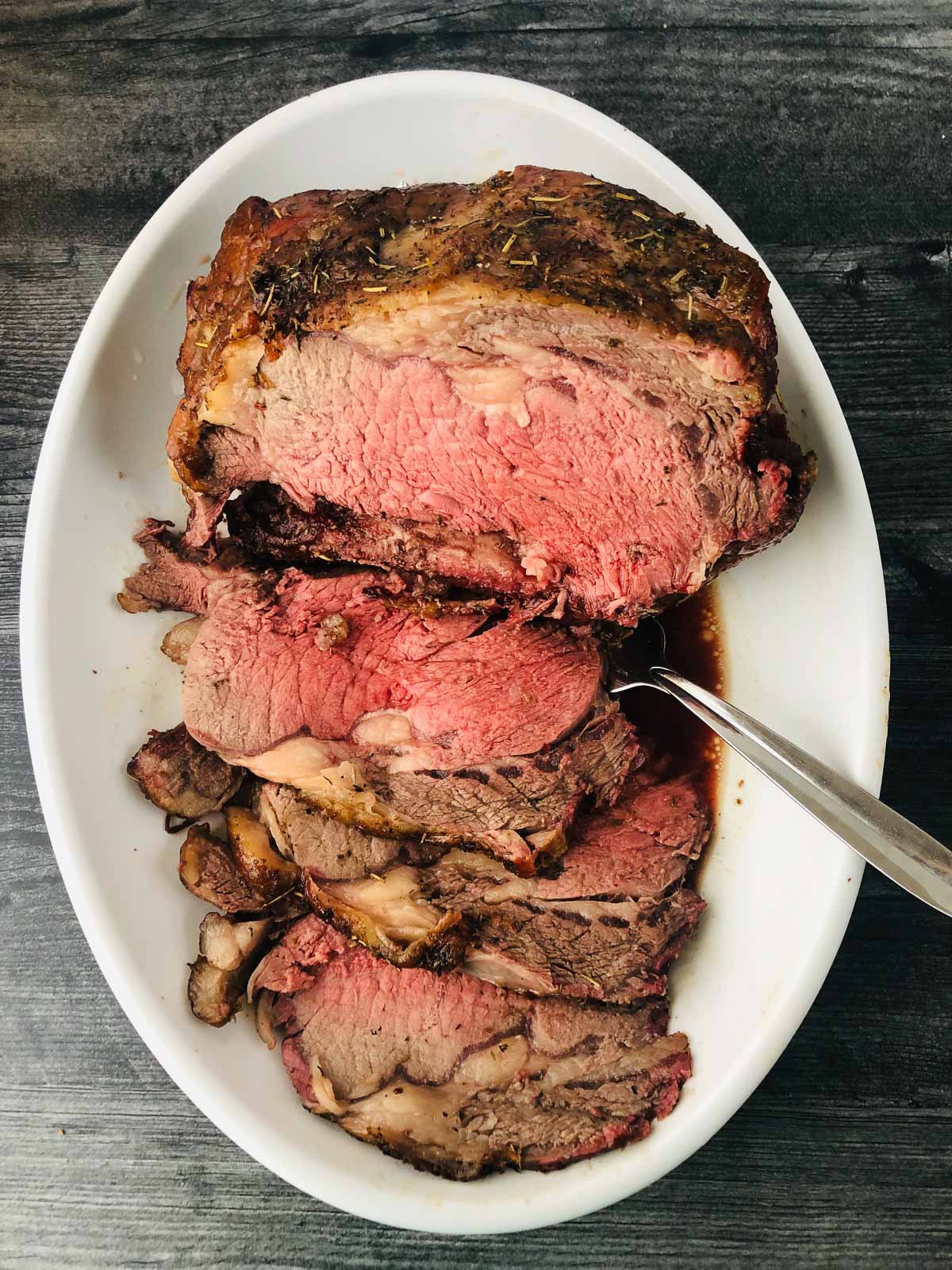 white platter with sliced roast beef made on the smoker