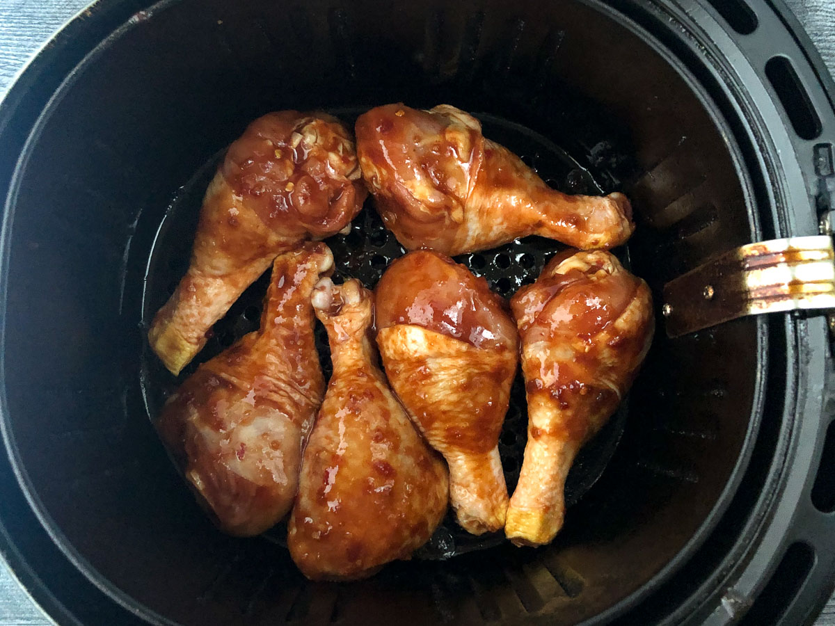 air fryer with raw marinated chicken legs with sticky sauce