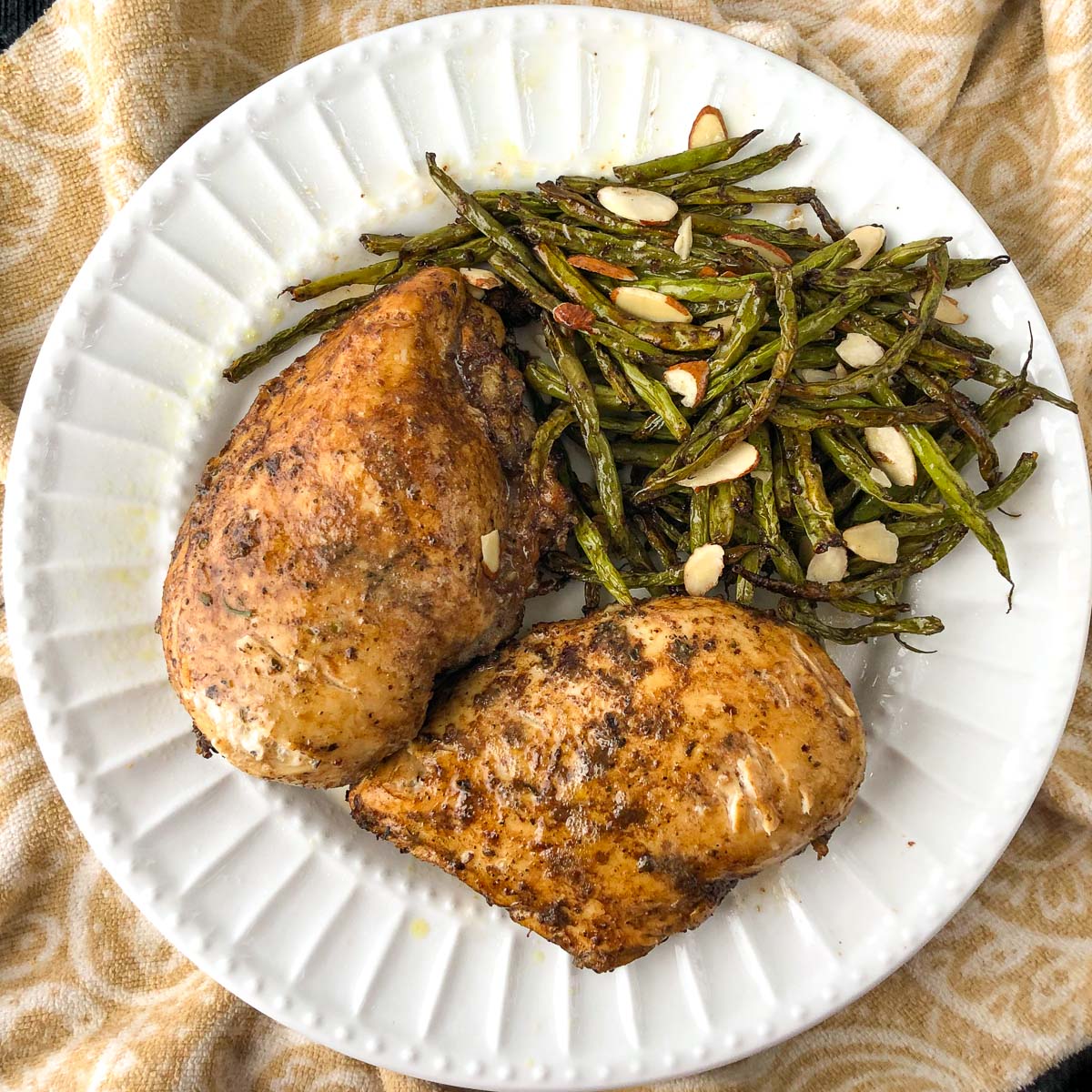 white plate with keto balsamic chicken and green beans made in the air fryer