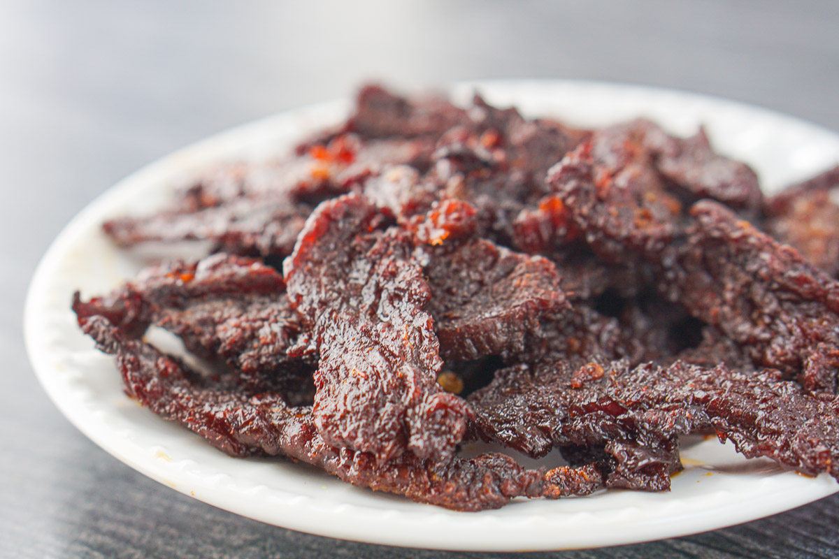 closeup of a white plate with marinated spicy beef jerky made in air fryer