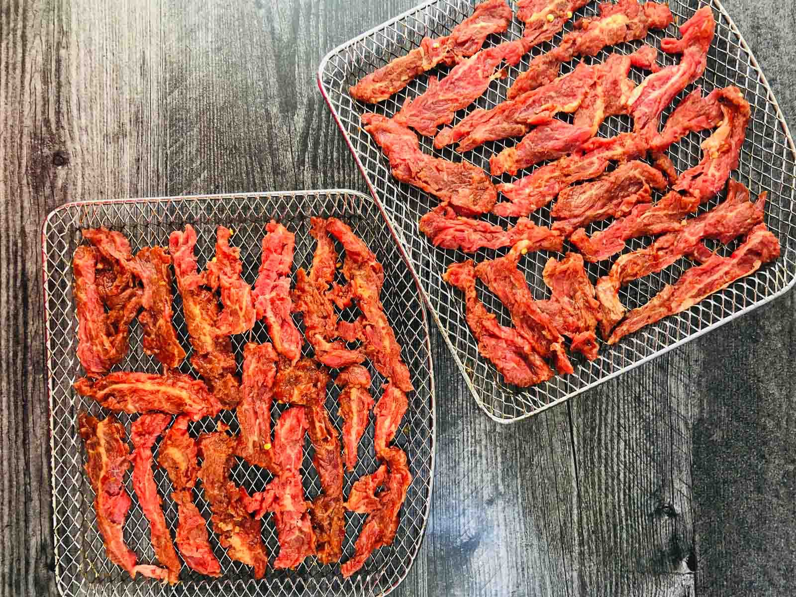 air fryer racks with raw pieces of marinate beef 