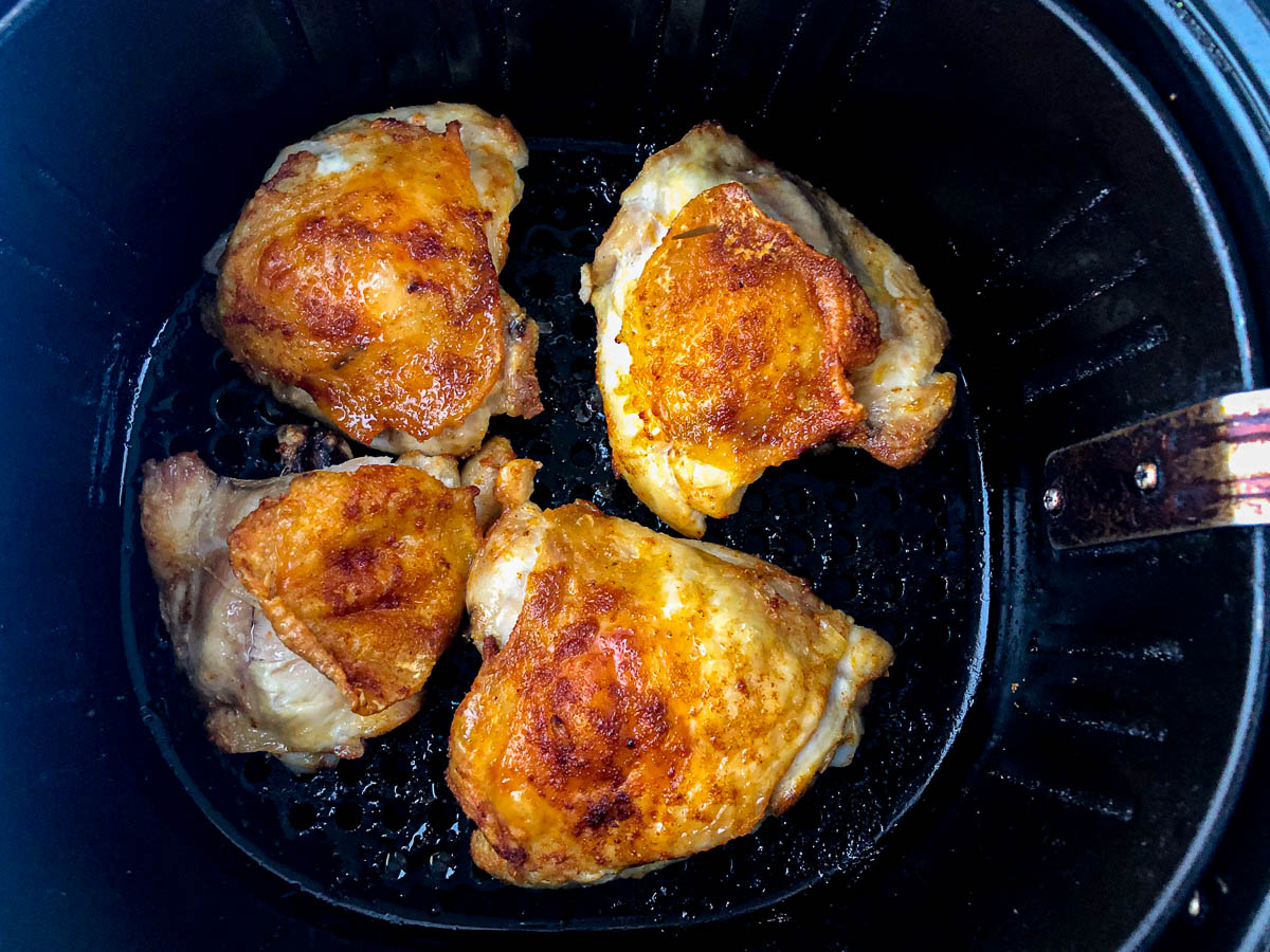 air fryer basket with crispy chicken thighs