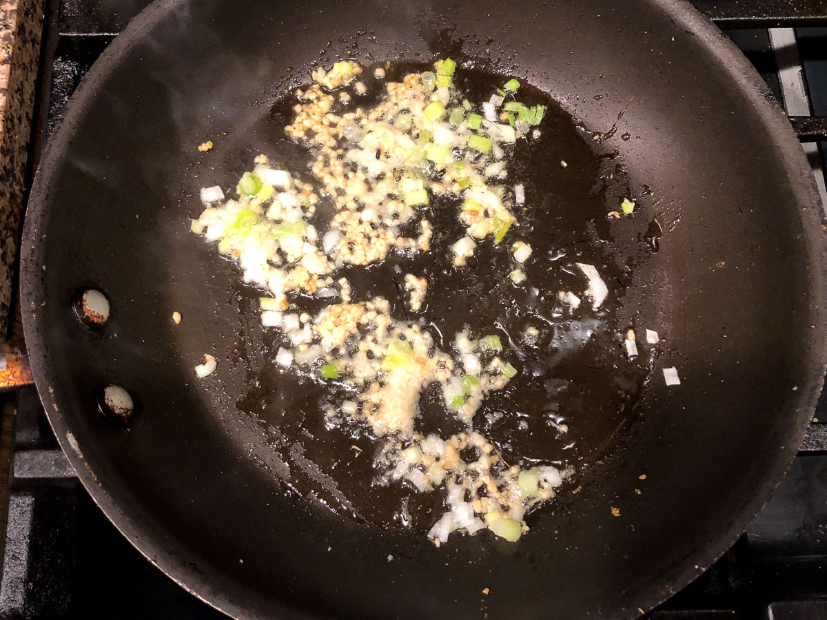 skillet with garlic, ginger and green onions