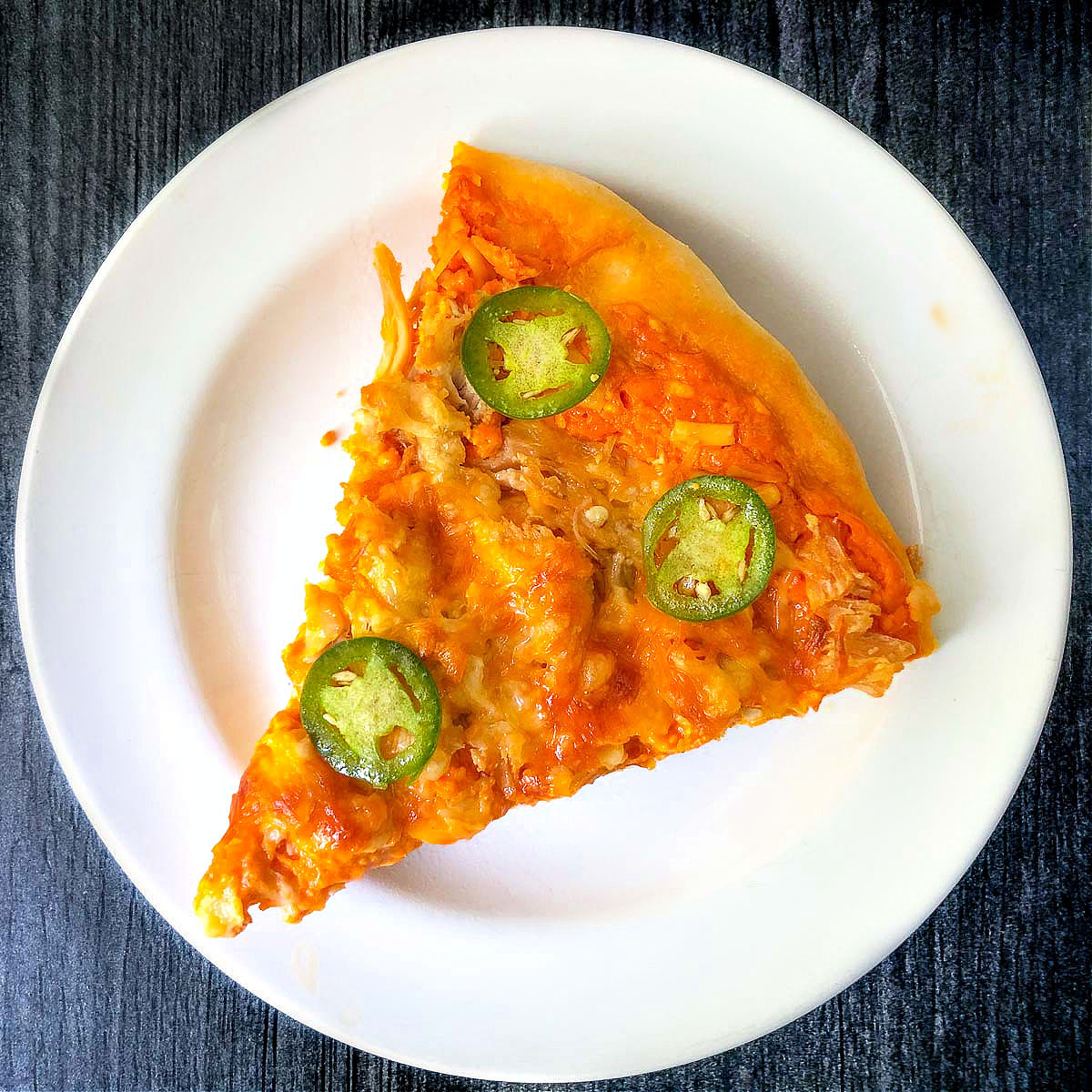 a slice of buffalo chicken pizza using 2 ingredient pizza crust on a white plate