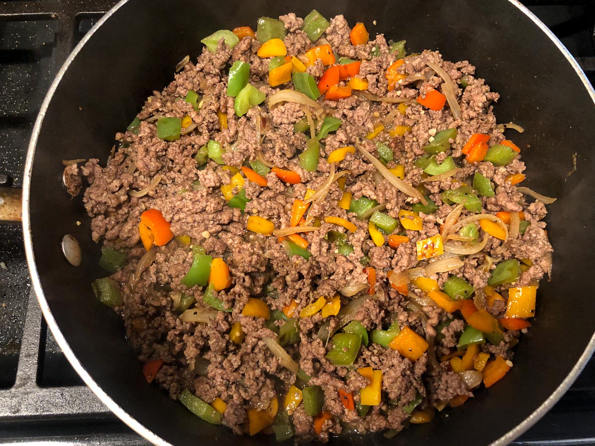 pan with browned ground beef, peppers and onions