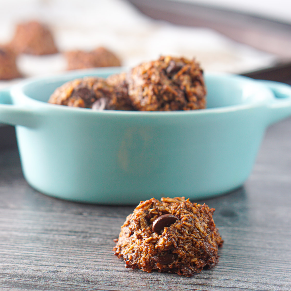 keto chocolate coconut cookies with a blue bowl in background