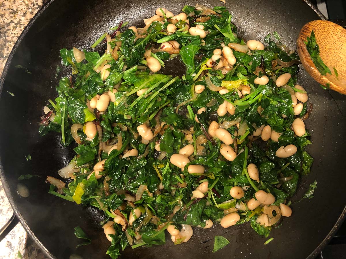These easy bacon beans & greens are the perfect way to use greens from your garden. Serve as a hearty side dish or as a main course. #SundaySupper Pan with the finished recipe.
