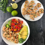 aerial view of a plate grilled keto shrimp kebabs and a shrimp rice bowl with fresh limes, avocado and cilantro and text