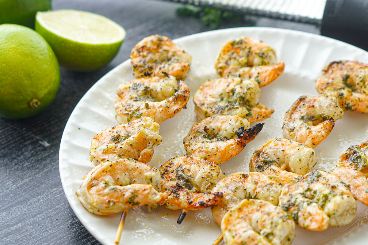 white plate with marinated grilled shrimp kebabs
