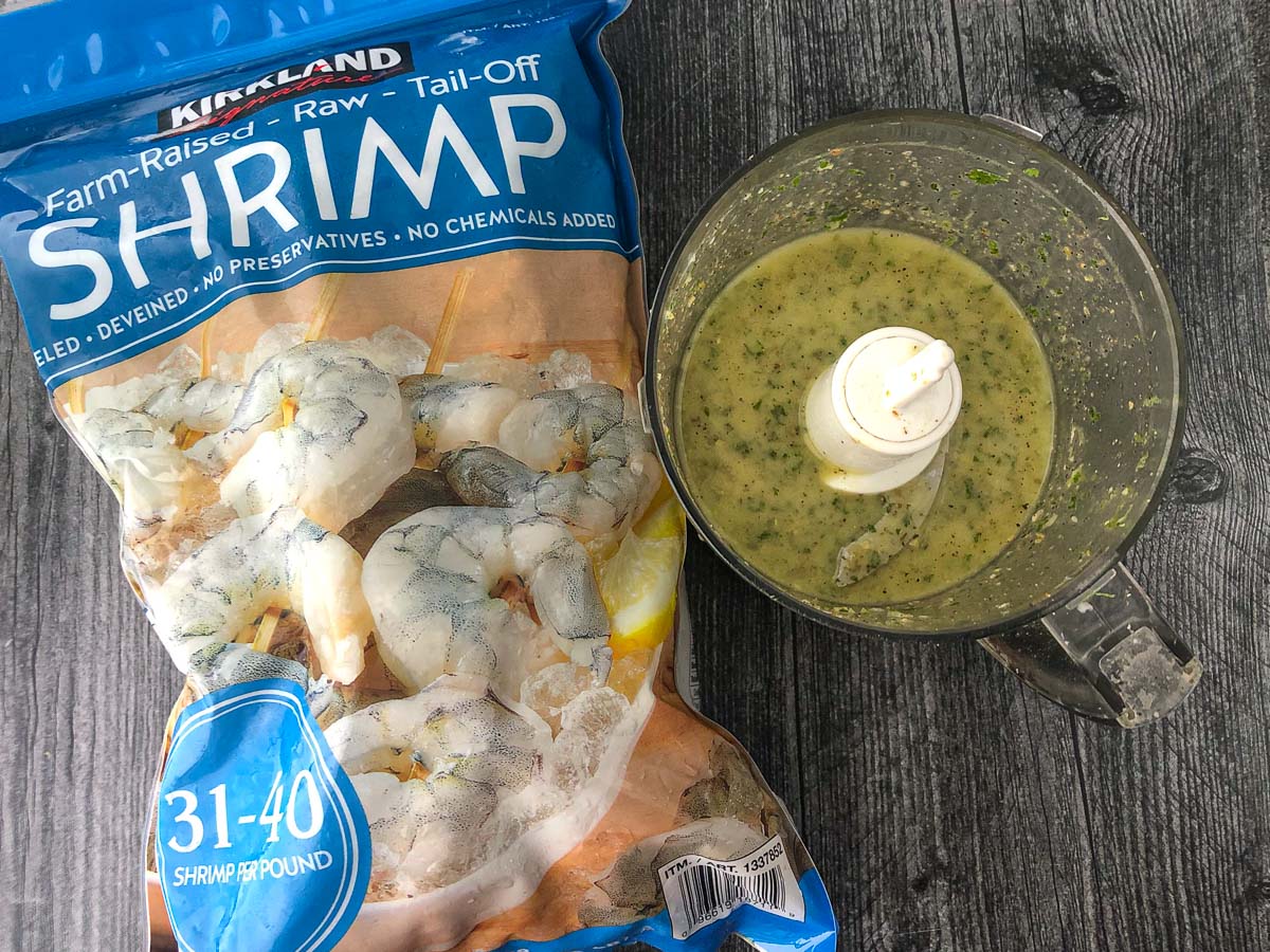bag of raw frozen shrimp and food processor with a marinade