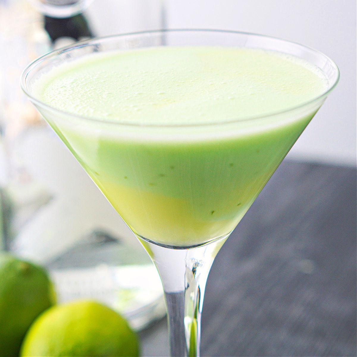 closeup of a keto key lime pie martini with fresh limes 