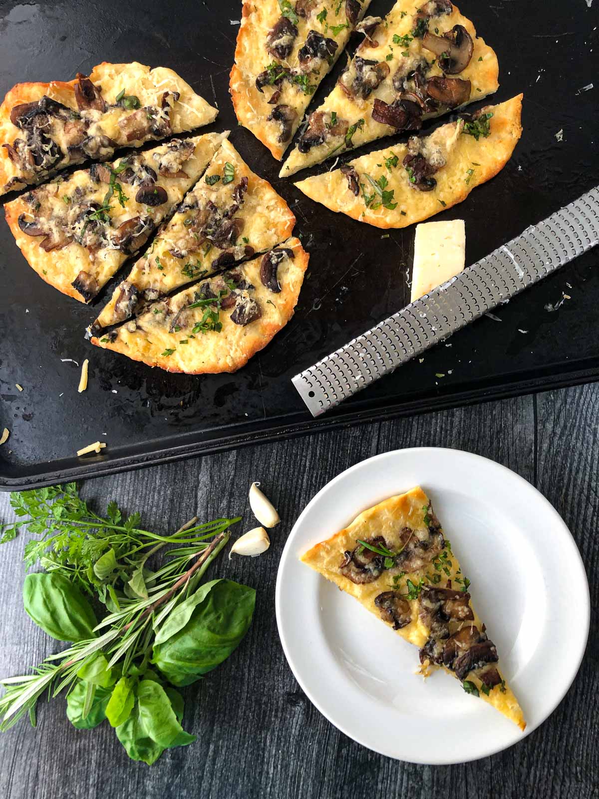 aerial view of a white plate and cookie sheet with air fryer mushroom flatbread