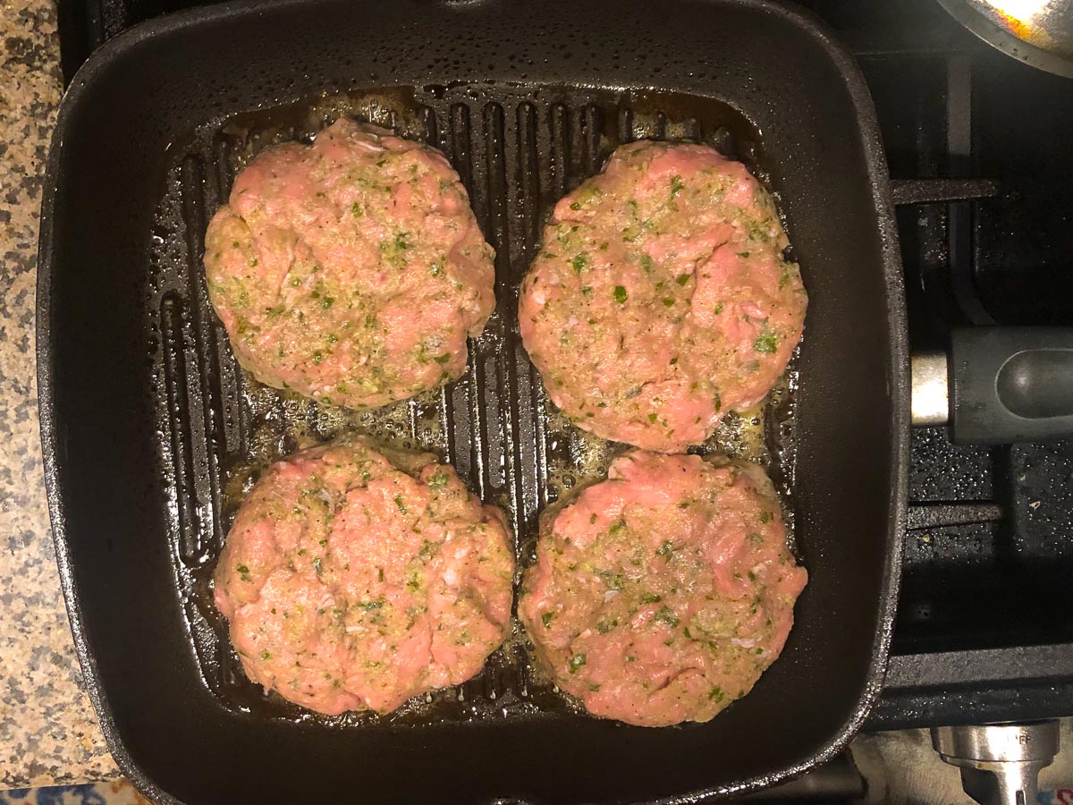 grill pan with 4 raw patties