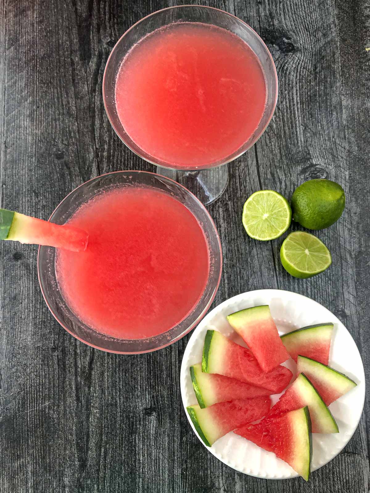aerial view of watermelon cosmo drink and sliced watermelon and limes