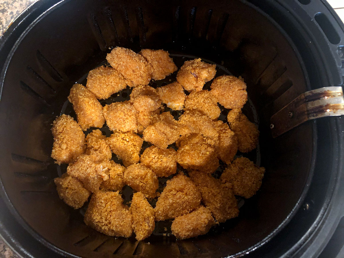 air fryer basket with uncooked nuggets