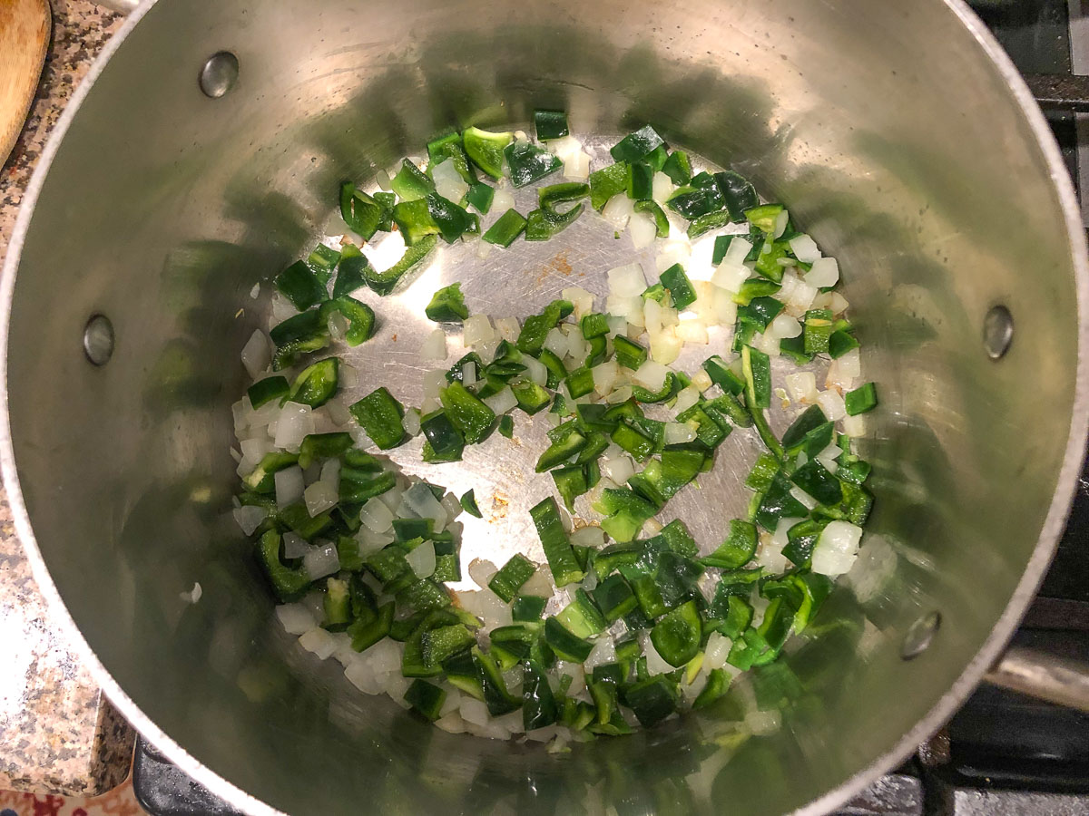 pot with sautéed onion and poblano peppers