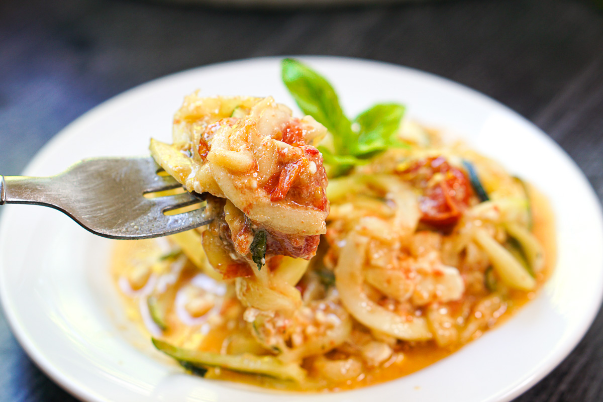 a forkful of zucchini noodles with baked feta and tomato sauce