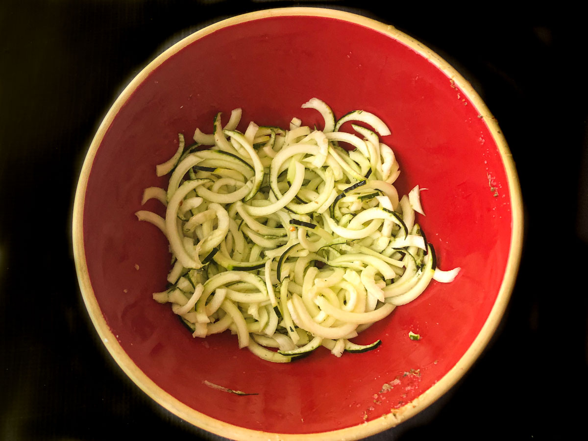 red bowl with cooked zucchini noodles