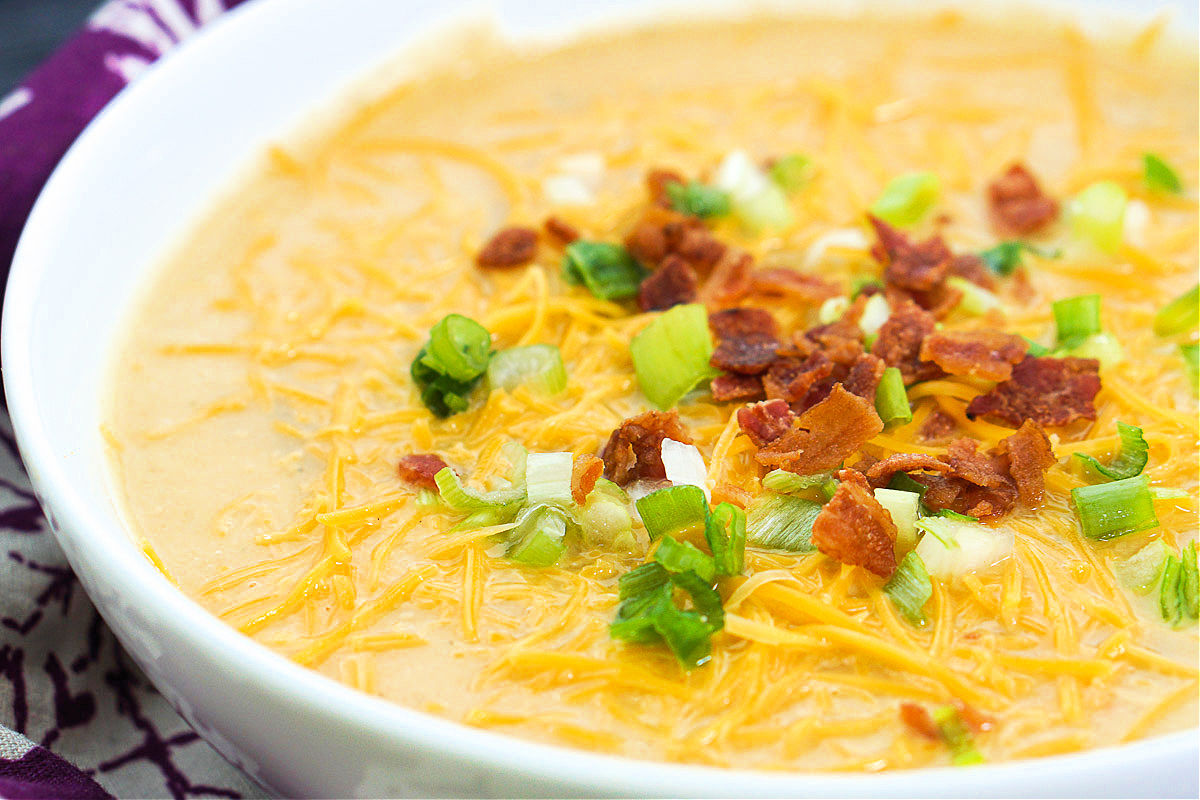 closeup of a loaded cauliflower soup with bacon bits and green onions
