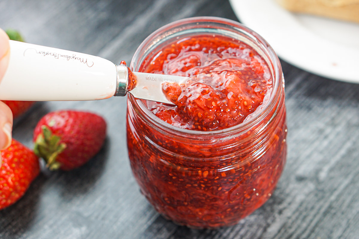 jar with chia jam made with strawberries and a knife