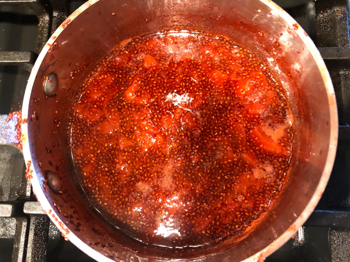 pan on the stove with cooked down berries