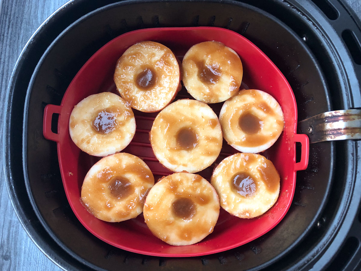 air fryer basket with raw apples with brown sugar and melted butter