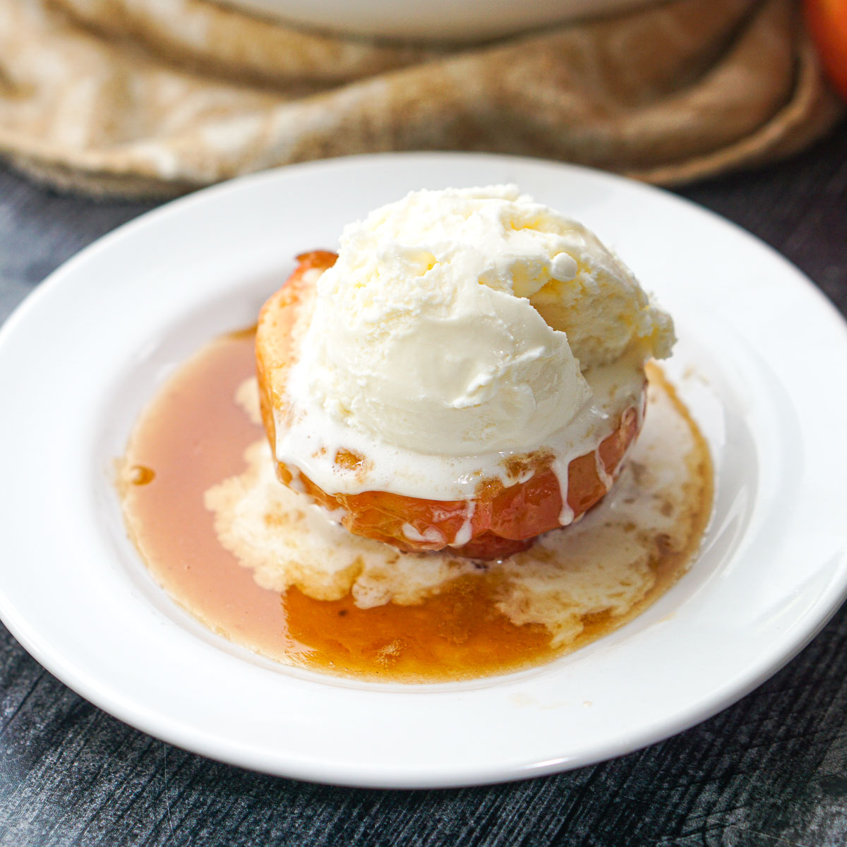 white plate with air fryer baked apple and ice cream