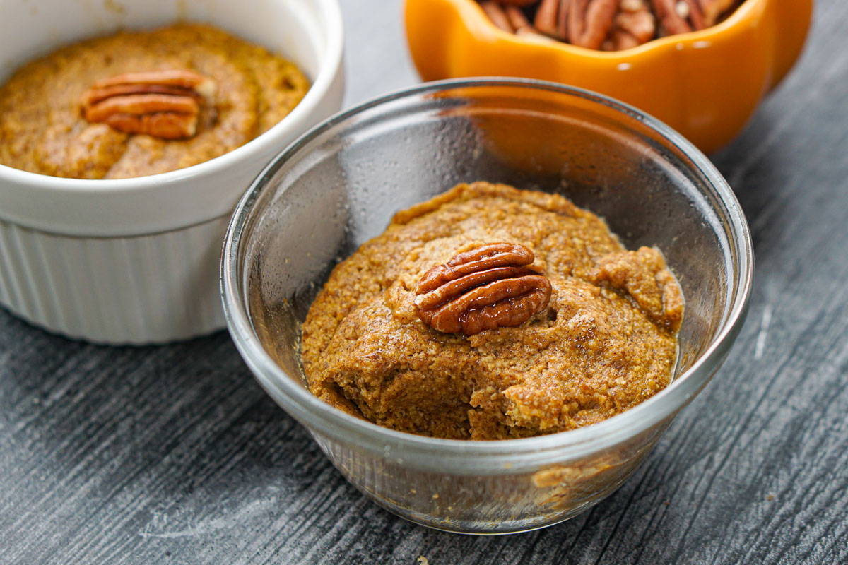baked pumpkin oatmeal with an orange bowl of pecans