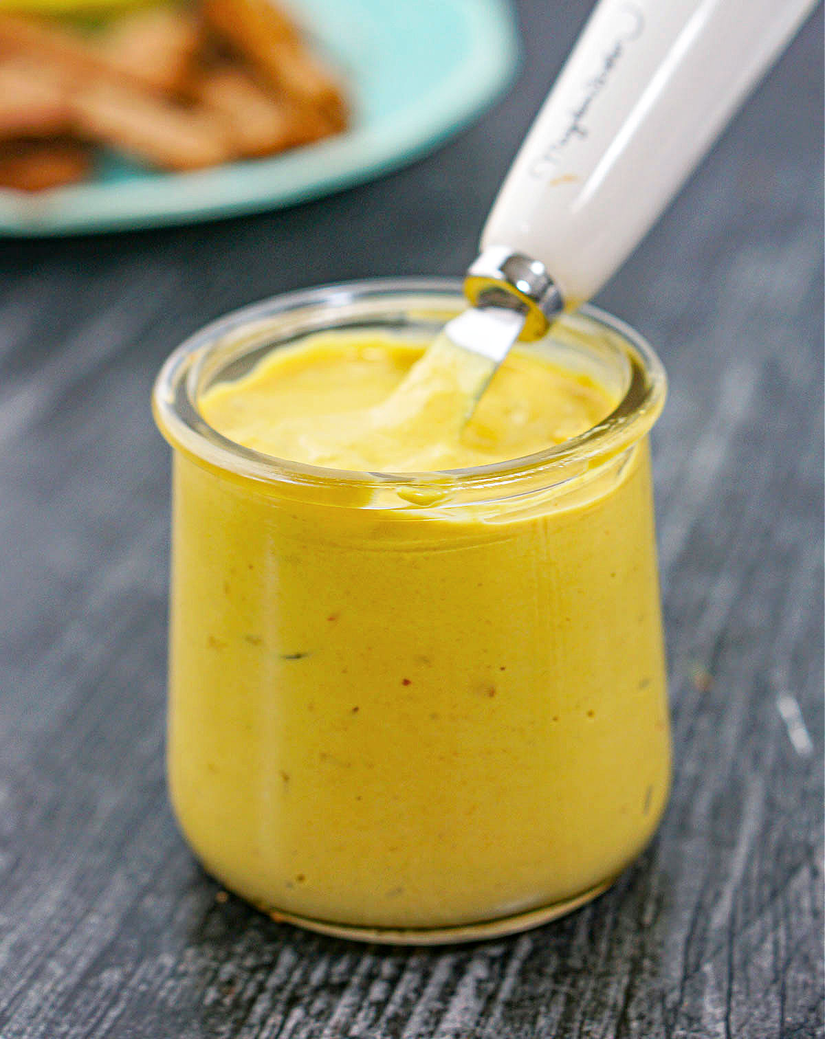 glass jar of homemade hot pepper mustard with a knife