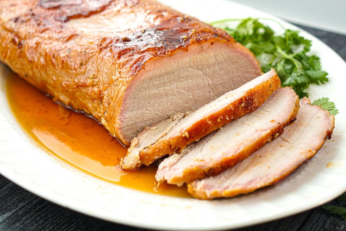 sliced smoked pork loin roast on white platter
