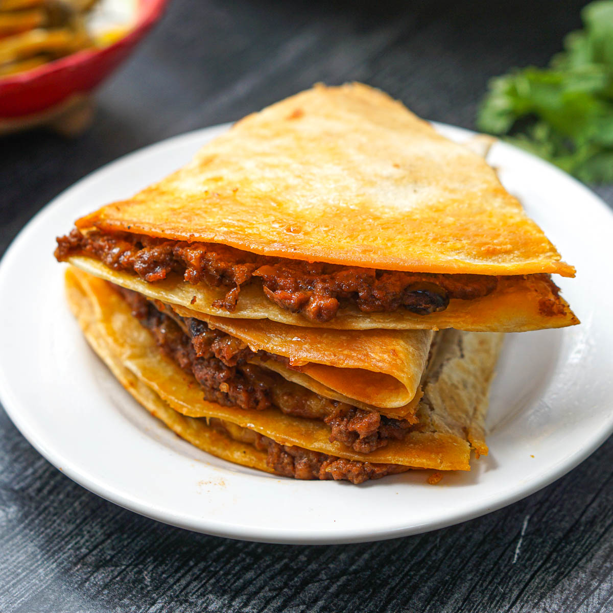a stack of chili quesadillas on white plate