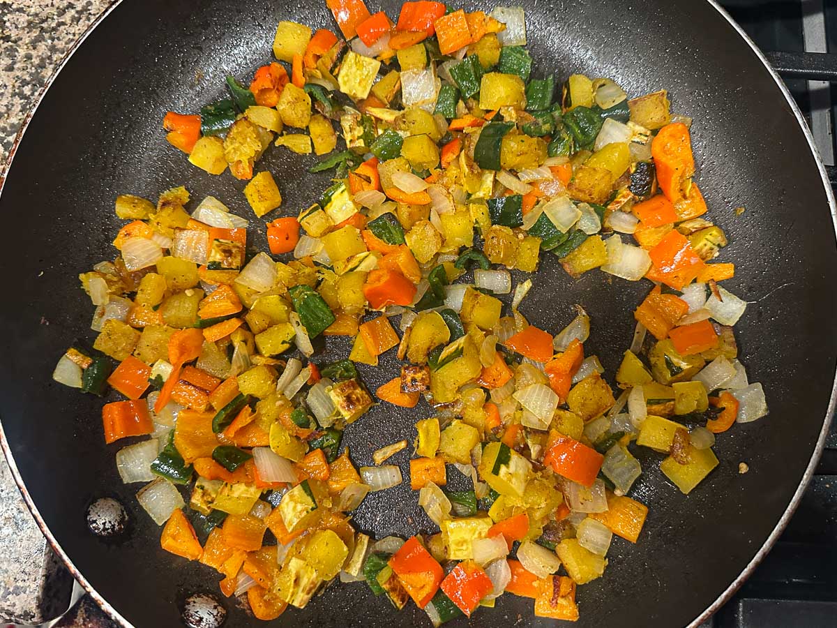 Skillet with the cooked delicata squash, peppers and onions.