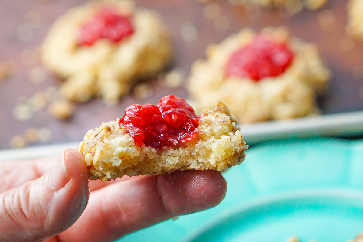 fingers holding the keto cookies with raspberry jam