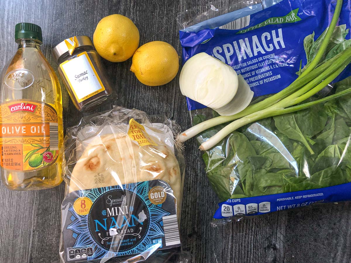 spinach pie ingredients - lemons, onion, green onion. naan bread, sumac and olive oil