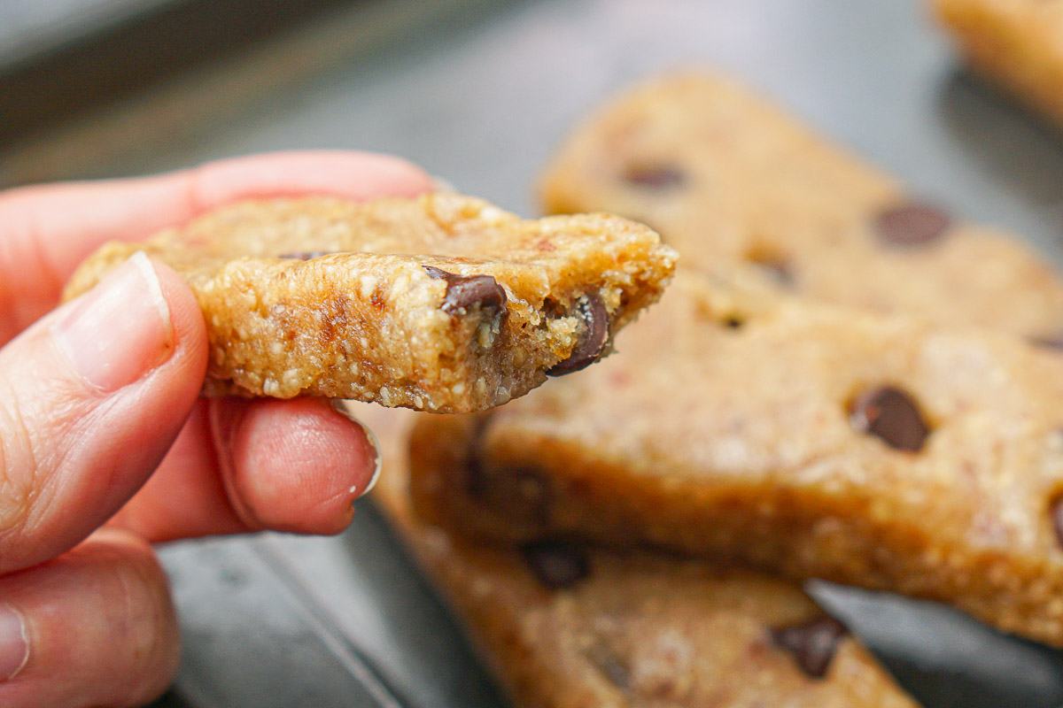 hand holding a homemade cookie dough bar with a bit taken out