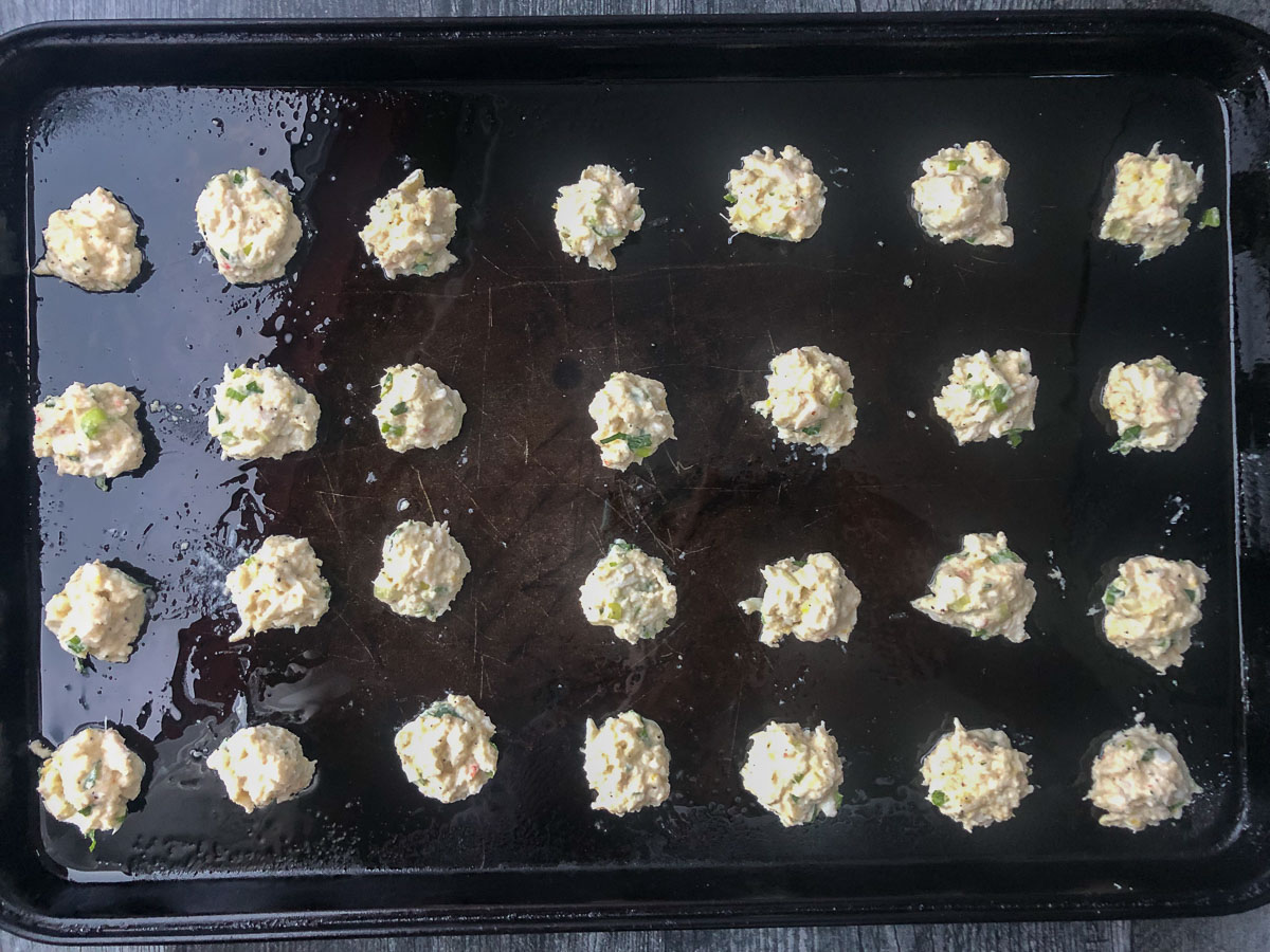 cookie sheet with uncooked crab cakes