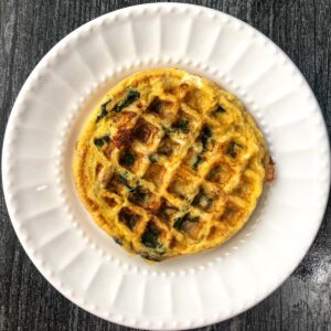 white plate with a veggie keto omelet waffle