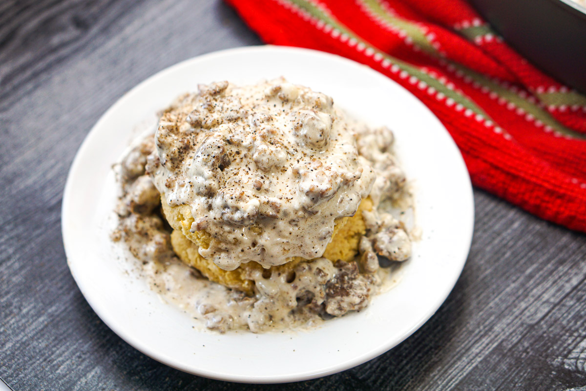 white plate with keto biscuits and sausage gravy