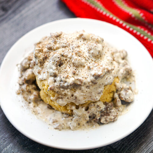 white plate with keto biscuit and sausage gravy