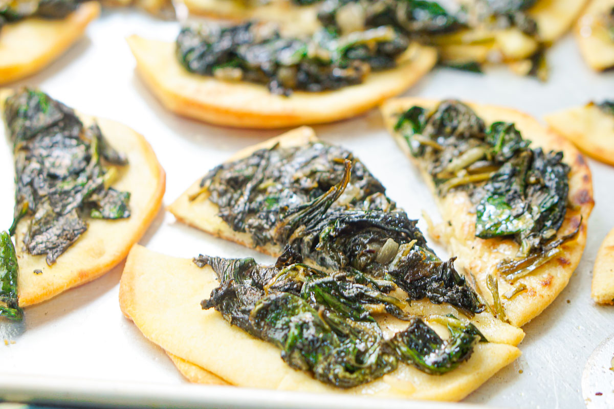 closeup of a tray of spinach fatayer using naan bread
