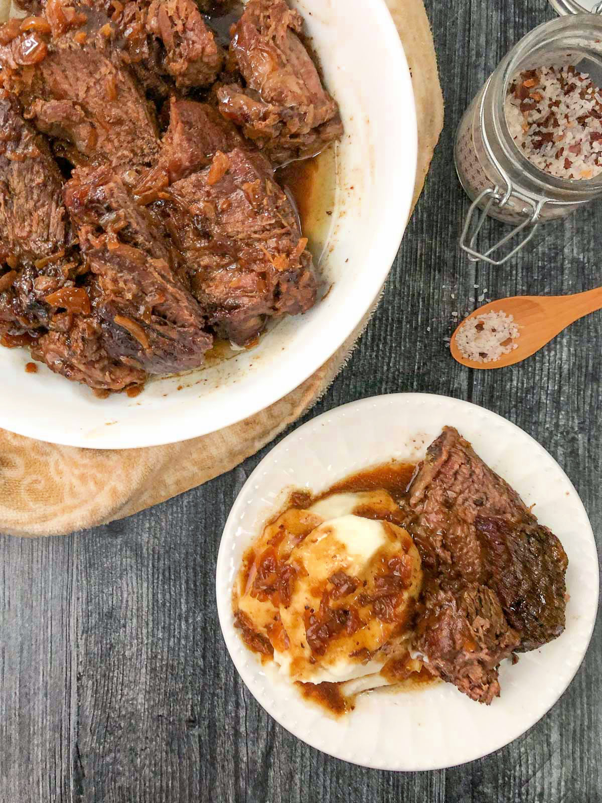 aerial view of a bowl of keto pot roast and a plate with mashed cauliflower and a piece of pot roast