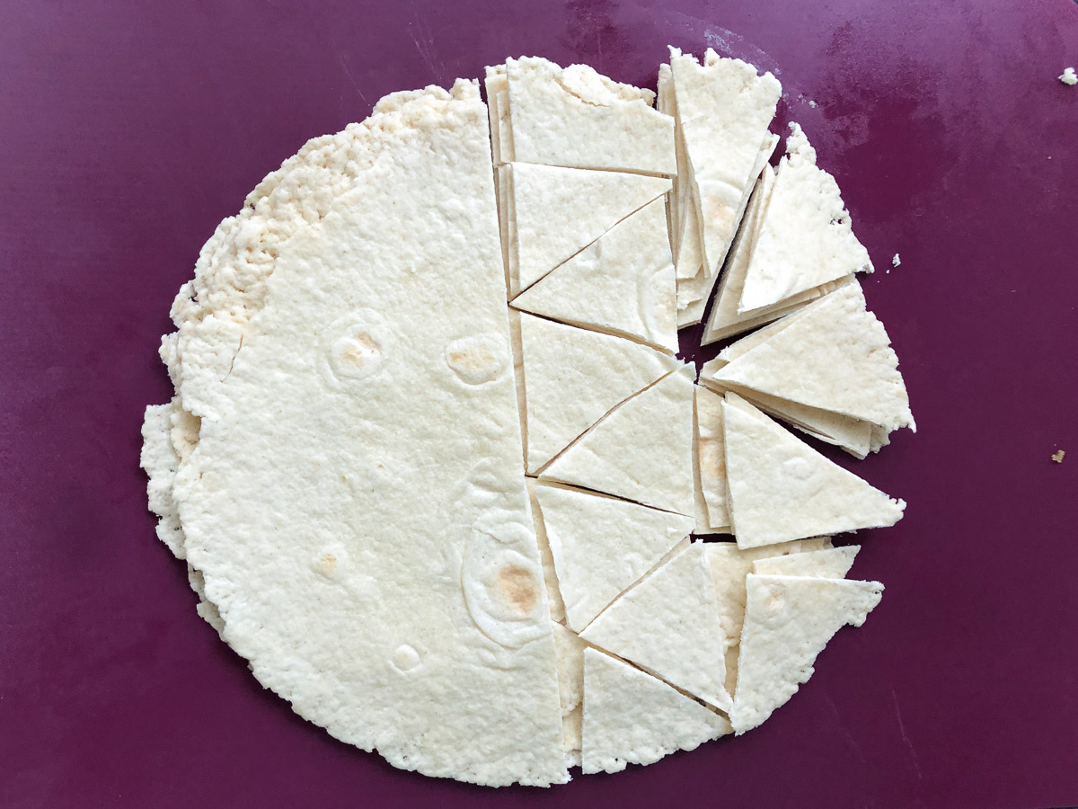 cutting board with tortillas stacked and cut into chips