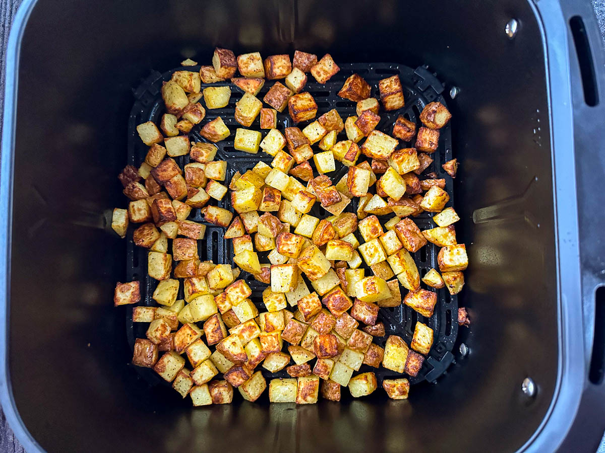 air fryer basket with fried potatoes