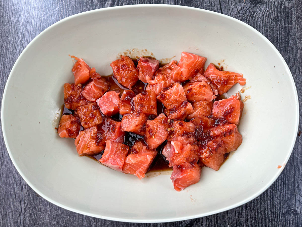 bowl with bite sized pieces of salmon in Asian marinade