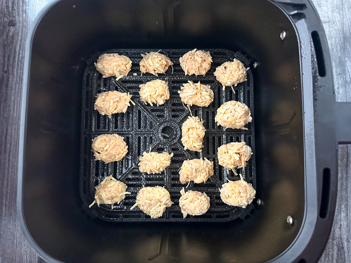 air fryer basket with raw nuggets